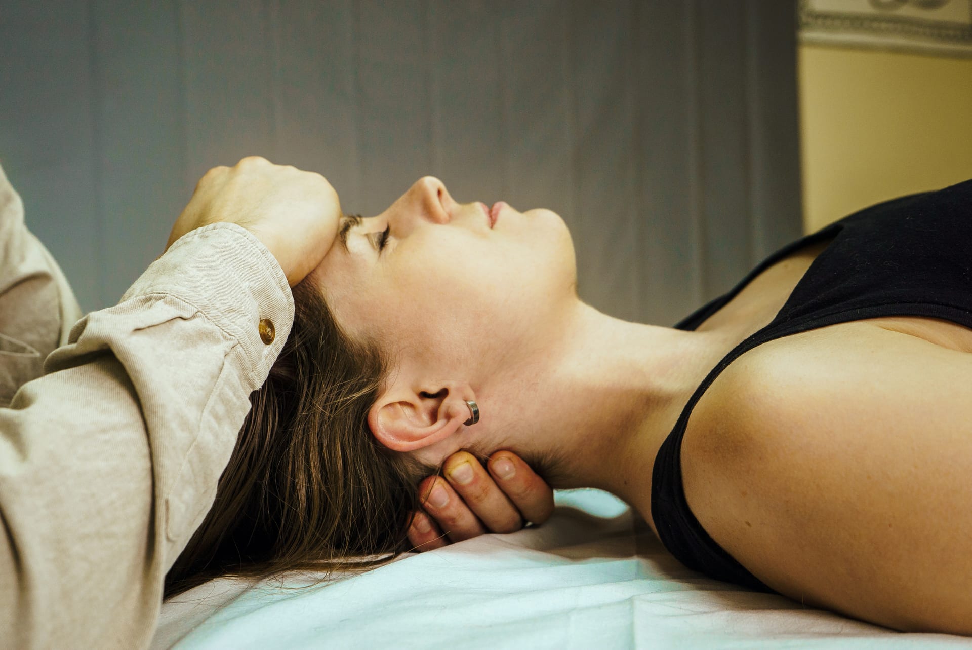 Therapist gently cradling a client's head and neck during a craniosacral therapy session